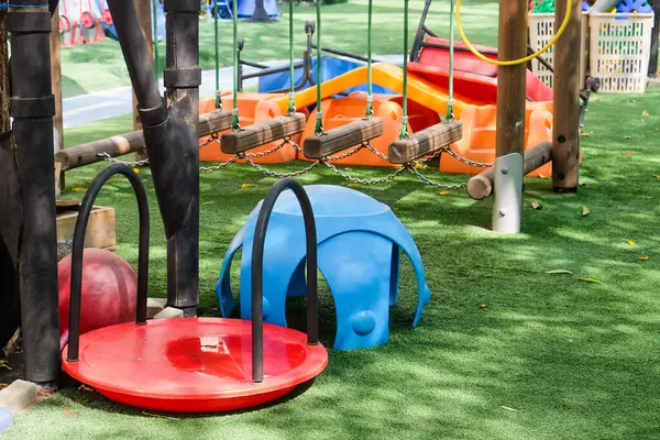 Spielplatz Park Mit Blauen Und Roten Sitzen Und Schaukeln lizenzfreie Stockbilder