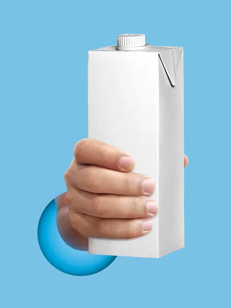 Kartong Mjölk Eller Juice Paket Handen Ljusblå Bakgrund — Stockfoto