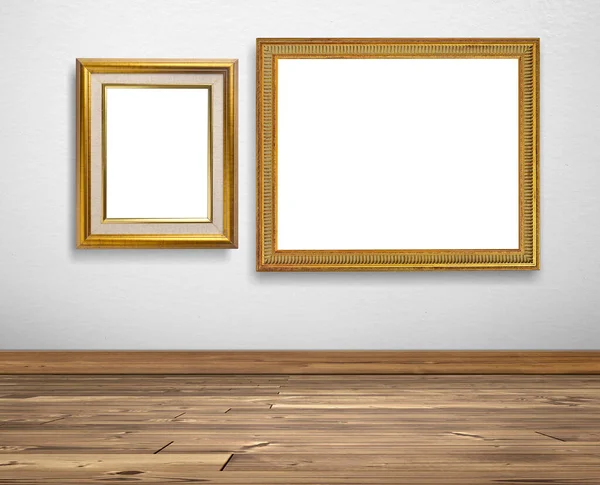 白い壁と木製の床の上の黄金の画像フレーム — ストック写真