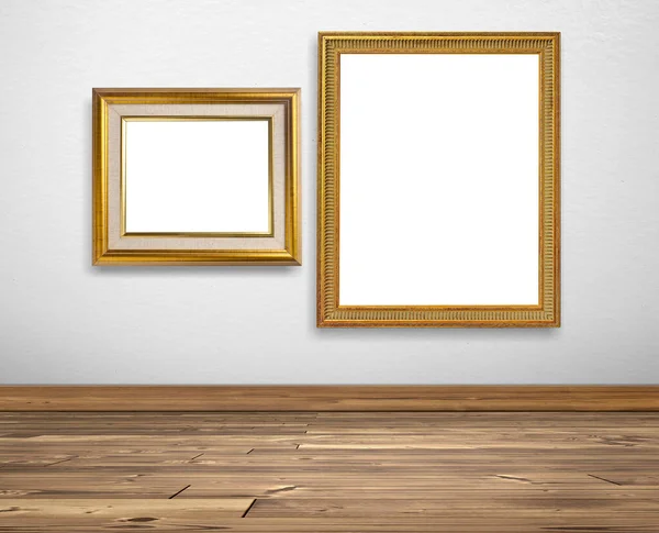 白い壁と木製の床の上の黄金の画像フレーム — ストック写真