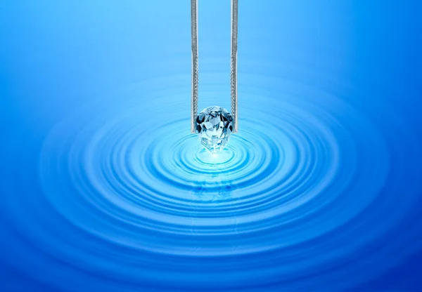 Diamantes Azuis Mantidos Pinças Água Ondulada Com Reflexão — Fotografia de Stock