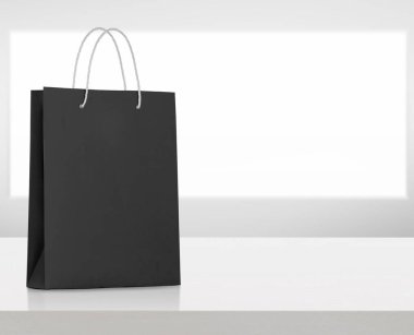 Siyah kağıt torba beyaz tahta masada.