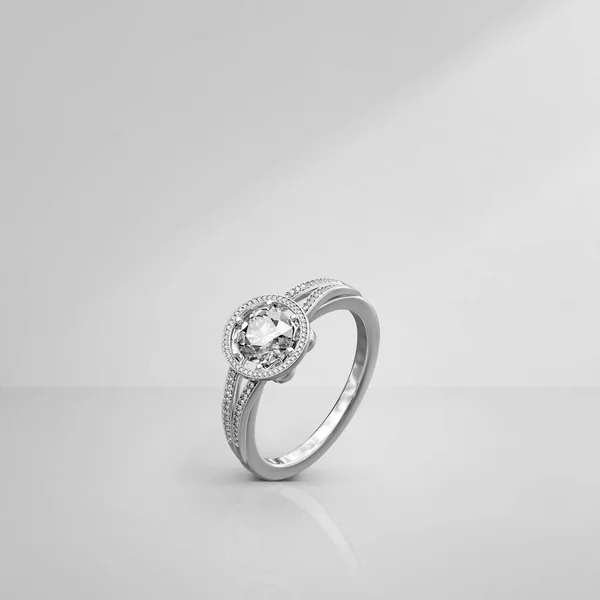 Elegant diamond ring on light background with shadows