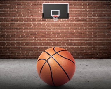 Basketbol topu ve basketbol potası tuğla duvarda ve beton zeminde.