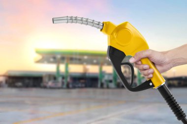 Benzin istasyonu ile karşı bir yakıt meme holding arka plan bulanık