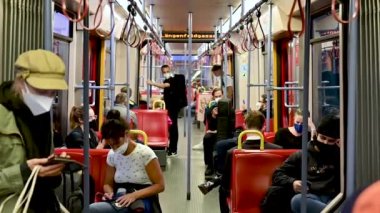 Viyana, Avusturya, Ağustos 2022. Metro vagonundaki hayat sahneleri: İnsanların kendilerini koronavirüsten korumak için maskeleri var, cep telefonlarını kullanmaya kendilerini kaptırmışlar..