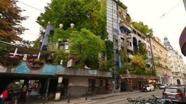 Viyana, Avusturya, Ağustos 2022. Viyana 'daki Hundertwasser evinin bitkileri ve ağaçlarıyla dolu renkli yüzün inanılmaz görüntüleri. Konut, apartman.