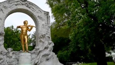 Viyana, Avusturya, Ağustos 2022. Stadtpark, Viyana, Avusturya 'da Johann Strauss' un altın heykeli olan anıt. Güzel bir yaz günü. Pan hareketi.