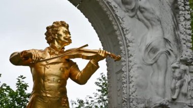 Viyana, Avusturya, Ağustos 2022. Stadtpark, Viyana, Avusturya 'daki Johann Strauss' un altın heykelinin ön planında yer alan anıt. Güzel bir yaz günü.