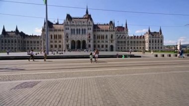 Budapeşte, Macaristan, Ağustos 2022. Parlamentoya doğru yürüyen muhteşem pov. Daha çok insan bu görkemli binanın cephesine doğru ilerliyor...