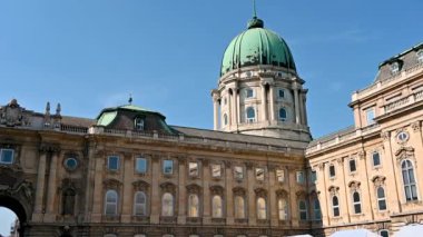 Budapest, Hungary, August 2022. Slow motion footage with the big green dome of the Buda Castle sticking out over the building.