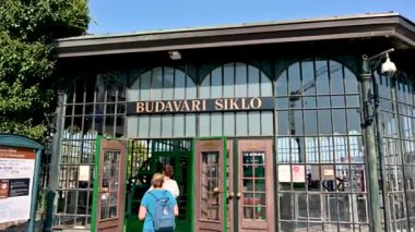 Budapest, Hungary, August 2022. Shooting outside the top station of the cable car: perfectly preserved and functional glass and metal structure, people can be seen heading to boarding for the descent.