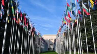 Geneva, Switzerland, January 2023. Slow motion footage with wide angle lens and low angle shot: iconic image of the headquarters of the united nations. In the courtyard the flags of the member states.