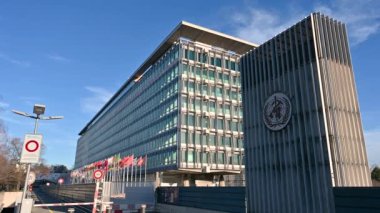 Geneva, Switzerland, January 2023. Beautiful footage with the united nations headquarters. In evidence on the right the logo, on the left the flags flutter slowly. Sunny day.