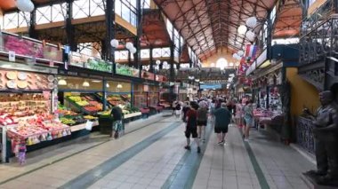 Budapest, Hungary, August 2022. Immersive pov footage in the central market. We scroll among the people and then walk along the stalls of souvenirs with the goods on display.
