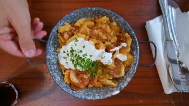 Budapeşte, Macaristan, Ağustos 2022. Yerel bir spesiyalitesi olan iştah açıcı bir yemeğin üst görüntüsü: Patates, et ve domates sahnenin hakimi..