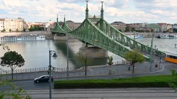 2022年8月 匈牙利布达佩斯 从上面看到的自由桥倾斜的镜头 一辆独特的橙色和白色老式有轨电车沿着它行进 人行道上的人 — 图库视频影像