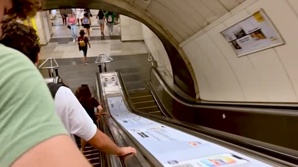 ブダペスト ハンガリー 2022年8月 メトロエスカレーターのハメ撮り映像 二人の若い男が手すりにしがみついて駅に降りると — ストック動画