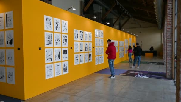 ミラノ ロンバルディア イタリア 2023年4月 イタリアの漫画家の元のページと展覧会 人々は黄色の壁に沿ってそれらを読むために停止します 自由な時間 — ストック動画