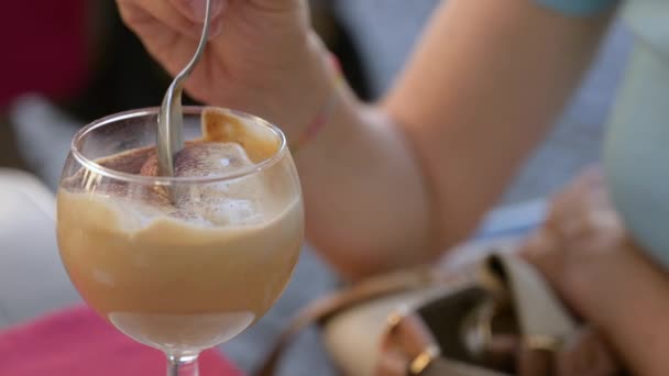 夏のコーヒークリームの喜び 前景には ココアで乾燥したクリームでいっぱいのガラス 女性の手はクリームにスプーンを浸し いくつかをスクープします — ストック動画