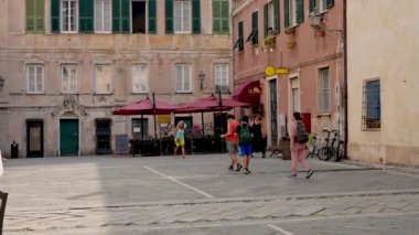 Finalborgo, Savona ili, Liguria, İtalya. 20 Eylül 2020. Ana meydandaki insanlar taşlarla döşenmiş. Dönem evlerinin rengarenk bir yüzü var..