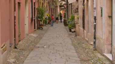 Finalborgo, Savona ili, Liguria, İtalya. 20 Eylül 2020. Tarihi köyün karakteristik bir sokağının büyüleyici bir yan görüntüsü. Taş döşeme, renkli yüzler, arka plandaki insanlar..