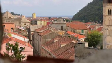 Finalborgo, Liguria, İtalya kalesinin duvarlarındaki bir boşluktan inanılmaz pov görüntüleri. Sağdaki manzarada çan kulesi ve tarihi köy. Uzakta Ligurian Denizi.