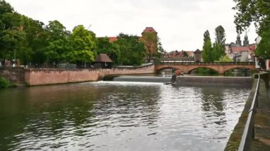 Nuremberg, Almanya, 1 Ağustos 2023. Tarih merkezini geçen nehir boyunca inanılmaz görüntüler var: kaplanmış yaya köprüsünün arkasında, tarihi binalar göz ucuyla görülebilir. Yağmurlu gün.