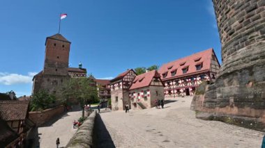 Nuremberg, Almanya, 1.2023. Şatonun şehrin üzerinde yükselişinin inanılmaz görüntüleri. Güzel bir yaz günü, kulenin bayrağını vurguluyorsun. İnsanlar.