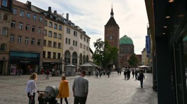 Nuremberg, Almanya, 1 Ağustos 2023. Tarihi merkezde şehir hayatı. Beyaz kulenin arka planında Ehekarussell çeşmesi ayaklarının altında, insanlar bu güzel yaz gününde geziniyorlar..