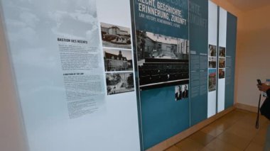 Nuremberg, Almanya, 1 Ağustos 2023. Anıtın bilgi panelleri, Nuremberg davalarına adanmış müze. Bir yandan, bir turistin elleri cep telefonuyla fotoğraf çekiyor..