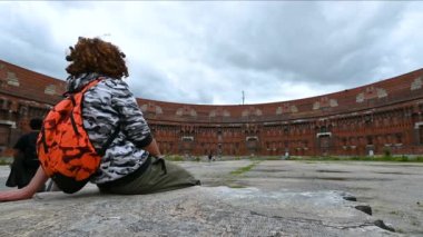 Nuremberg, Almanya, 1 Ağustos 2023. Nazi askeri mitingleri alanında, kongre merkezinin tamamlanmamış yapısını izleyen iki gencin görüntüleri.