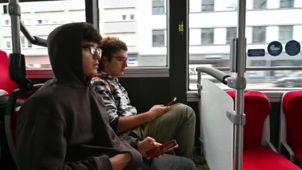 Dois Jovens Conversam Enquanto Estão Sentados Ônibus Usando Seus Telefones — Vídeo de Stock
