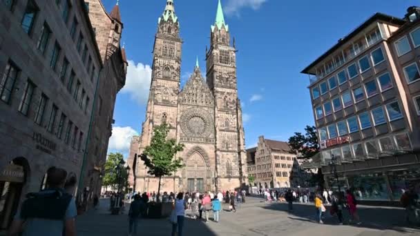 ニュルンベルク ドイツ 2023年8月1日 晴れた日のサンロレンツォ教会の美しい映像 白い雲が青空に流れ 人々は教会の前を歩いている ティルトムーブメント — ストック動画