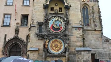 Prag, Çek Cumhuriyeti, 4 Ağustos 2023. Güzel astronomik saatin önünde toplanan kalabalığın görüntüsü, yağmurlu bir günde atlıkarıncanın zamanı gelmesini beklemesine rağmen..