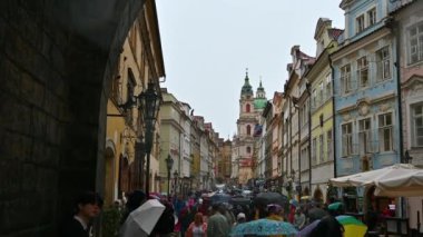 Prag, Çek Cumhuriyeti, 4 Ağustos 2023. Yağmurlu bir günde, Charles Köprüsü 'nden Mal Strana bölgesine doğru göz kamaştırıcı bir manzara. Renkli cepheler göze çarpıyor. Şemsiyeli bir sürü insan..