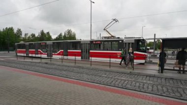 Prag, Çek Cumhuriyeti, 4 Ağustos 2023. Metro istasyonu görüntüleri, Depo Hostiva. Kırmızı ve beyaz tramvay durağa geliyor ve insanlar biniyor. Sığınakta dur işaretini görebilirsiniz..