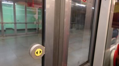 Prag, Çek Cumhuriyeti, 4 Ağustos 2023. Metro vagonundaki görüntüler. Sürgülü kapılar kapanıyor: yeni bir sürüş için ayrılmak üzereyiz. Sarı kapı açma düğmesi vurgulandı.