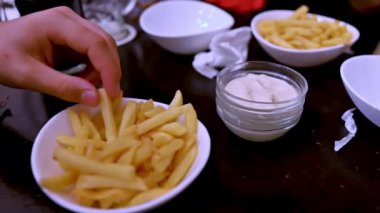 Kafkas bir adamın yemek yemeden önce sosa bandırmak için patates kızartmasını tutarken ki görüntüsü iştah açıcı. Yemeği, arkadaşlığı, eğlenceyi, eğlenceyi kutlarız..