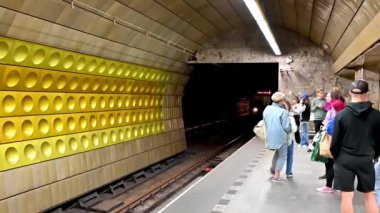 Prag, Çek Cumhuriyeti, 4 Ağustos 2023. Hardal durağında yavaş çekim. Platformdaki insanlar, metro konvoyu geliyor..