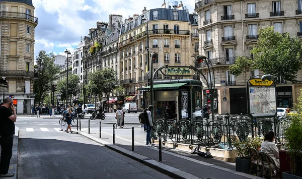 Paris, Fransa. Haziran 2022. Tarihi merkezde kendine özgü bir klasik tabelası olan güzel bir metro istasyonu manzarası var. Sokaktaki insanlar. Arka planda tarihi binalar var.