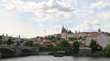 Prag, Çek Cumhuriyeti, 4 Ağustos 2023. Şehrin kartpostal görüntüsü: Tepedeki kale nehirden geçen bir turist teknesinin arka planıdır. Güzel bir yaz günü.