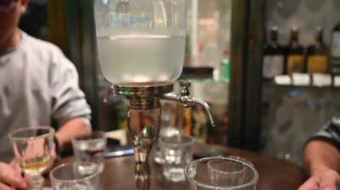 Prag, Çek Cumhuriyeti, 4 Ağustos 2023. Absinthe 'in eski bir kasaba barında yavaş yavaş dışarı çıkması için sürahiyle servis edilen büyüleyici yavaş çekim görüntüleri..