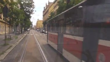Prag, Çek Cumhuriyeti, 4 Ağustos 2023. Hareket halindeki tramvayın içinden görüntüler alınıyor. Tramvayın arkasındayız ve rayların ve şehrin geçişini görüyoruz..