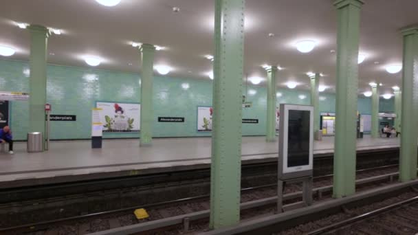 2023年8月10日 德国柏林 亚历山大广场地铁站的录像 平底锅的运动沿着月台运行 突出了标志与停止的名称 站台上的人 — 图库视频影像