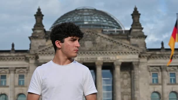 2023年8月10日 德国柏林 一个英俊的年轻人的慢镜头 他环顾四周 在旧议会大厦立面的背景下自拍 — 图库视频影像