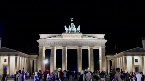 ベルリン ドイツ 2023年8月10日 ブランデンブルク門の美しい夜の映像 人混みのミーティングポイント ハイライトは ドアをマウントする馬の像です — ストック動画