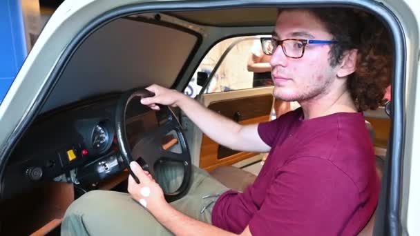 ベルリン ドイツ 2023年8月10日 ドイツ民主共和国Ddrから1950年代の車を運転しているカーリーヘアとメガネを持つ若い白人男性と素晴らしいスローモーション映像 — ストック動画
