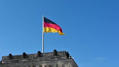 Berlin, Almanya, 15 Ağustos 2023. Almanya bayrağının Reichstag binasının çatısında dalgalandığı güzel, yavaş çekim görüntüleri. Vatansever kavramsal imaj.