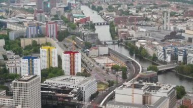 Berlin, Almanya, 15 Ağustos 2023. Hava manzaralı bir görüntü: Bakış ufka ulaşmak için Spree nehri boyunca akar. Nehir kenarına bakan modern renkli binalar.